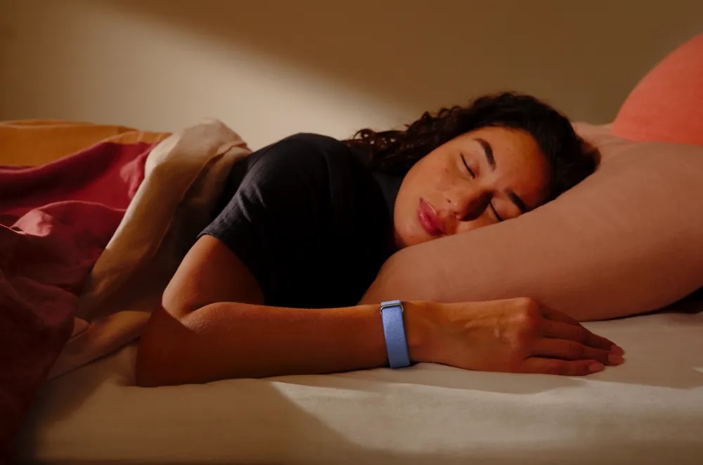 A women sleeping with a fitbit air on her wrist