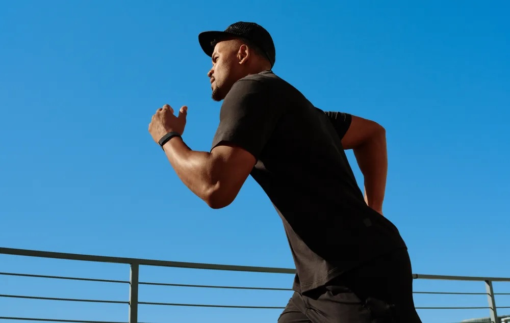A man running with a fitbit air on his wrist