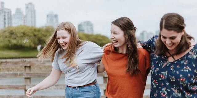 3 ladies walking and smiling together