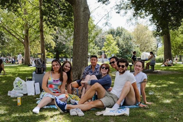 Group of friends taking a selfie together in a park, laughing
