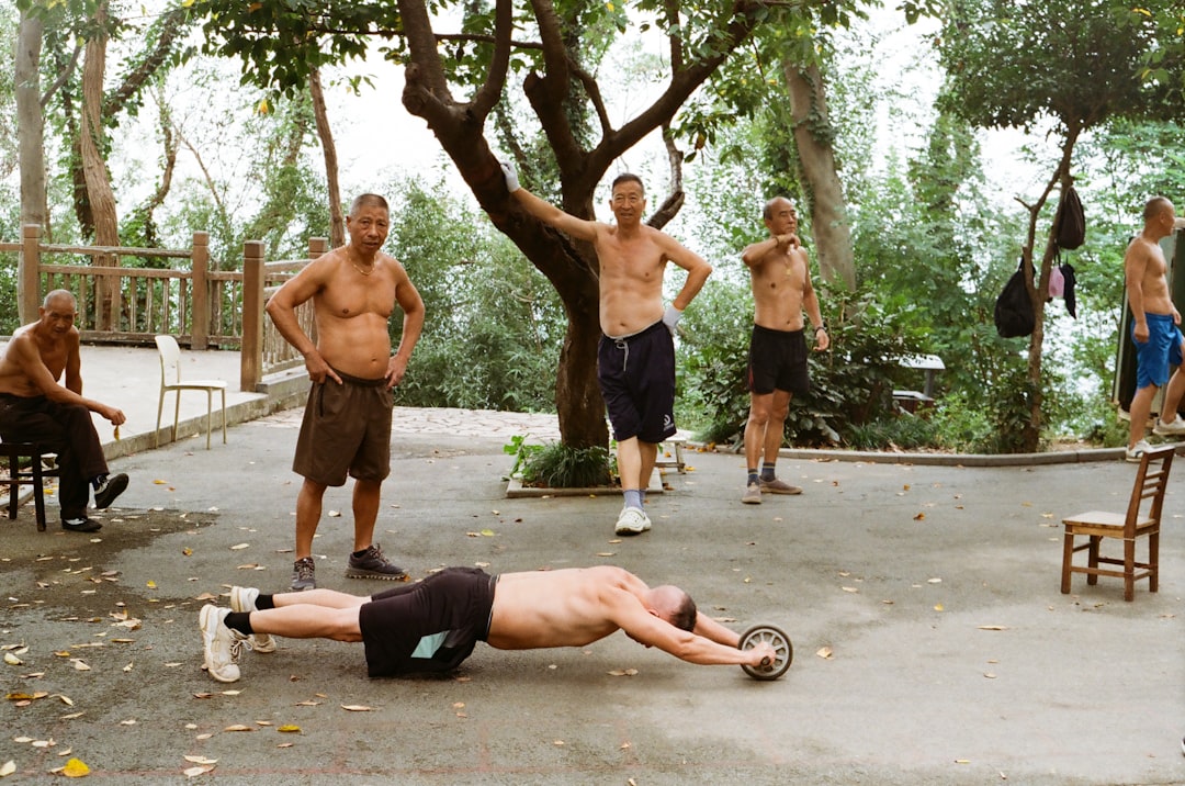 Two men exercising together outdoors with fitness equipment on grass