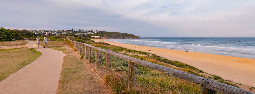 A group of men walking together along a coastal path at sunrise