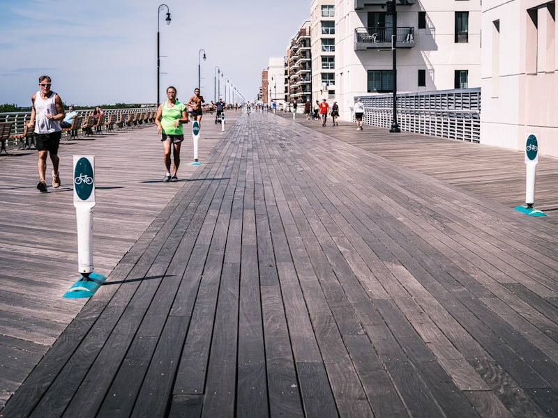 People jogging and walking along a coastal boardwalk path