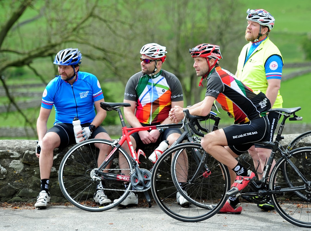 Four cyclists talking beside their road bikes during a countryside rest stop