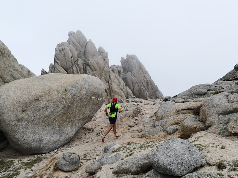 A runner moving along a trail between rock formations