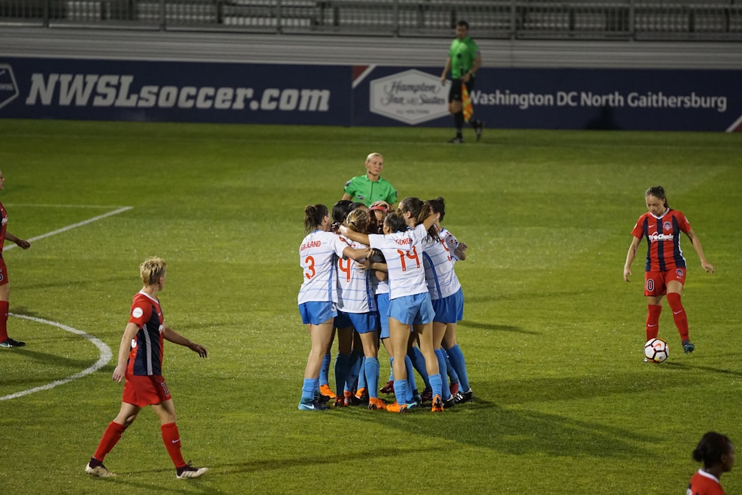 Group of soccer players hugging and celebrating together on the field