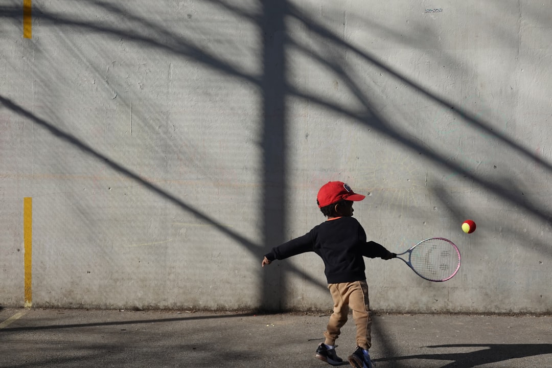 Young child practising tennis with a low-compression ball