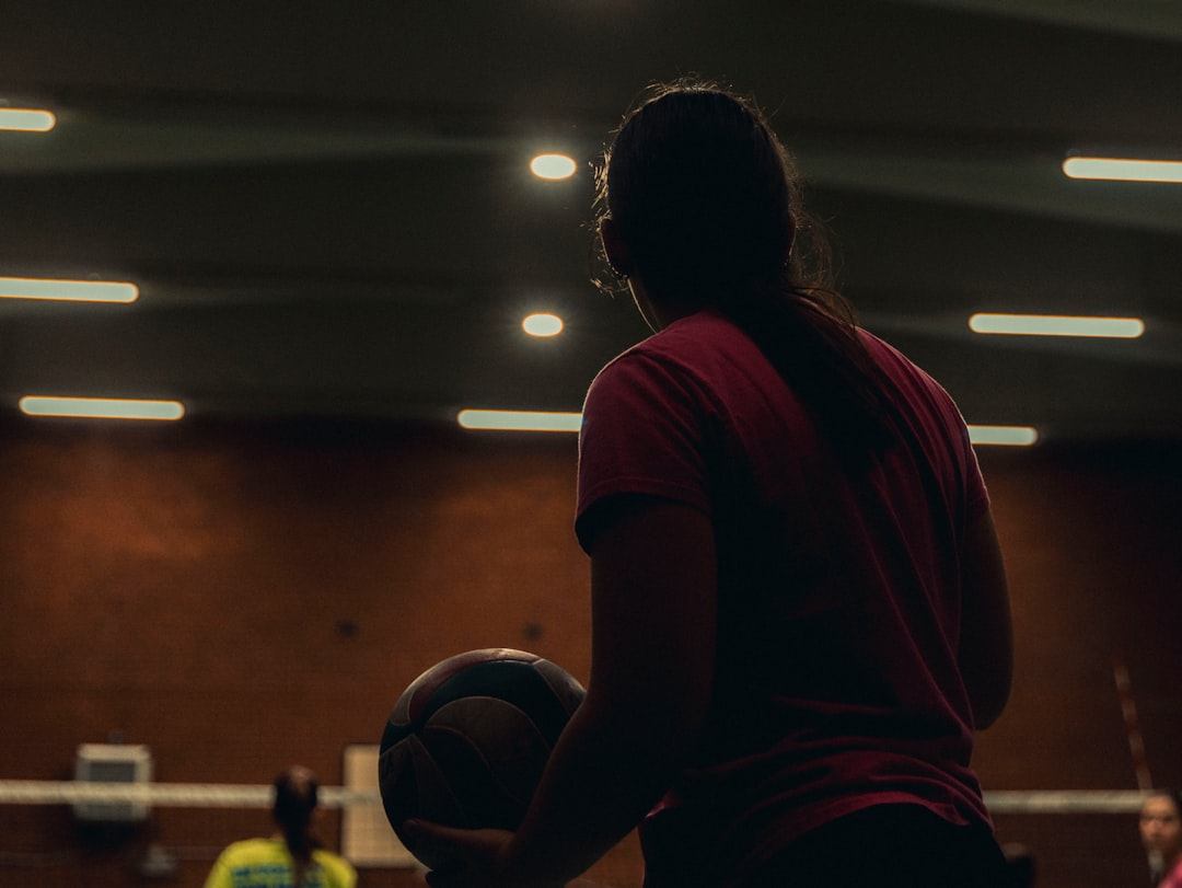 A young player holding a basketball in an indoor stadium