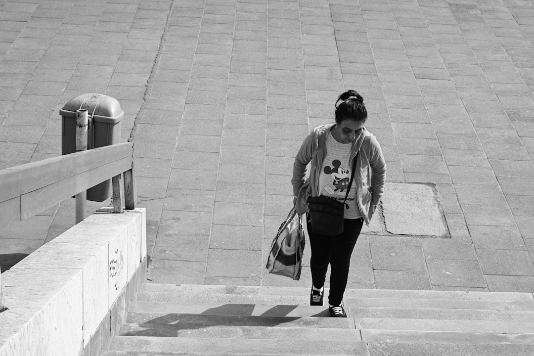 Woman carrying shopping bags up an external staircase to her home