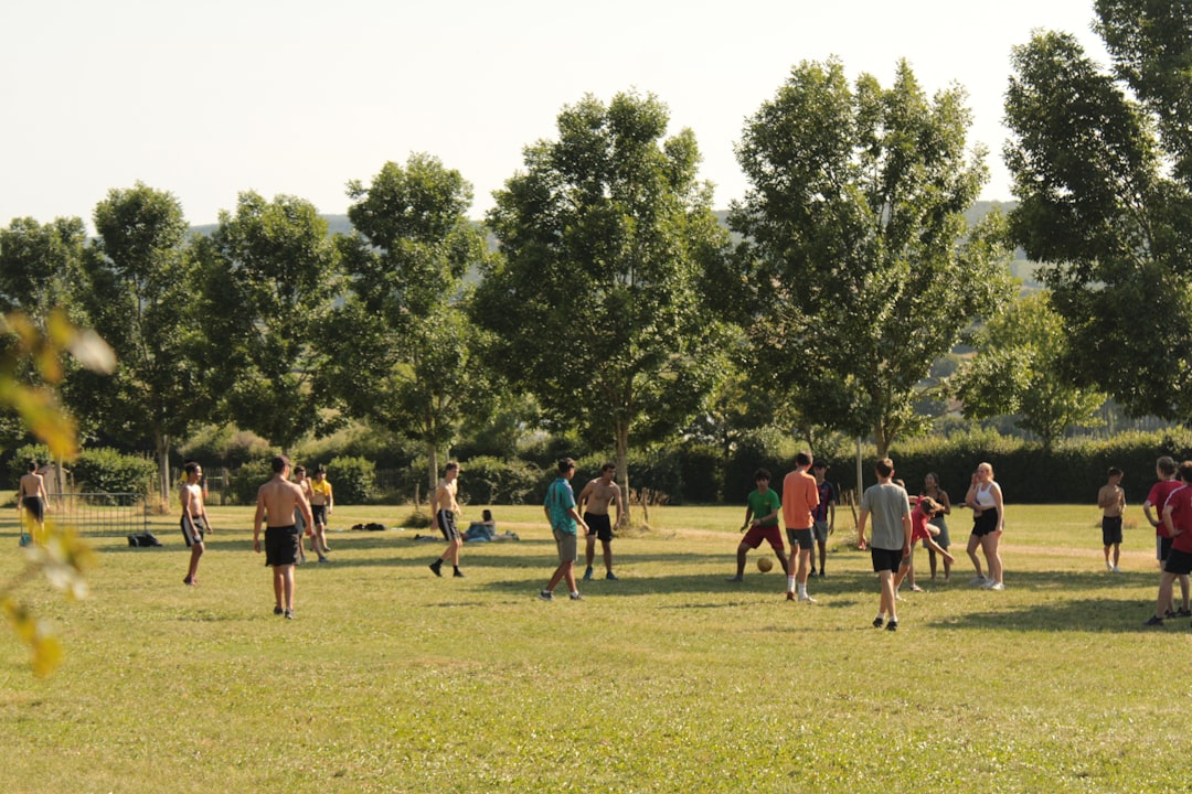 A group of friends gathered together on a green field after an outdoor fitness session