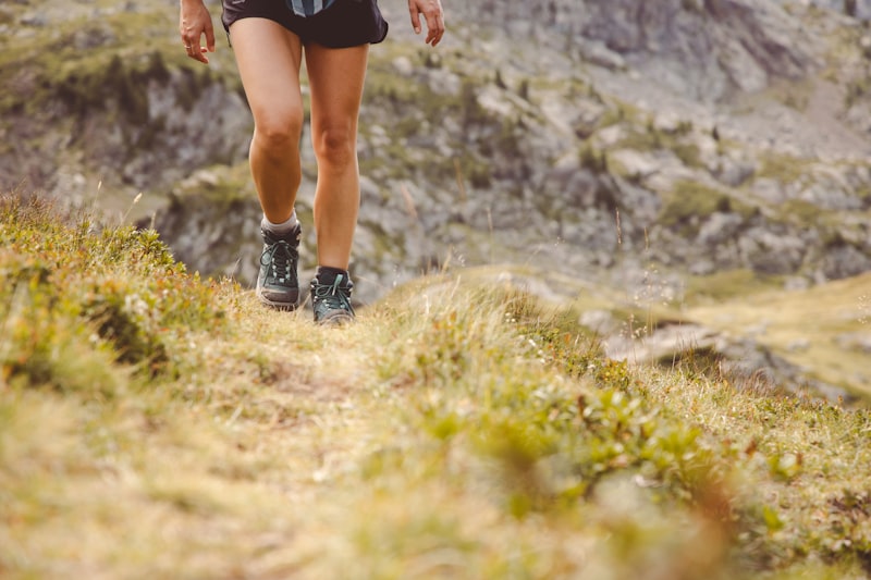 A woman running uphill on a mountain trail