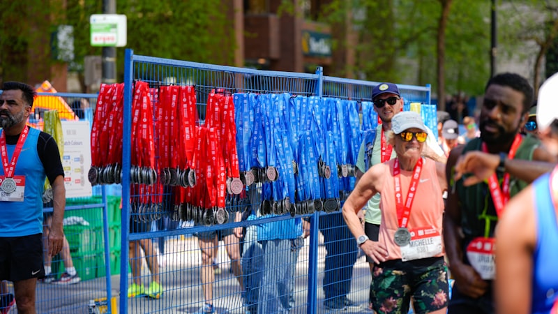 Runners at the finish of a fun run beside rows of medals