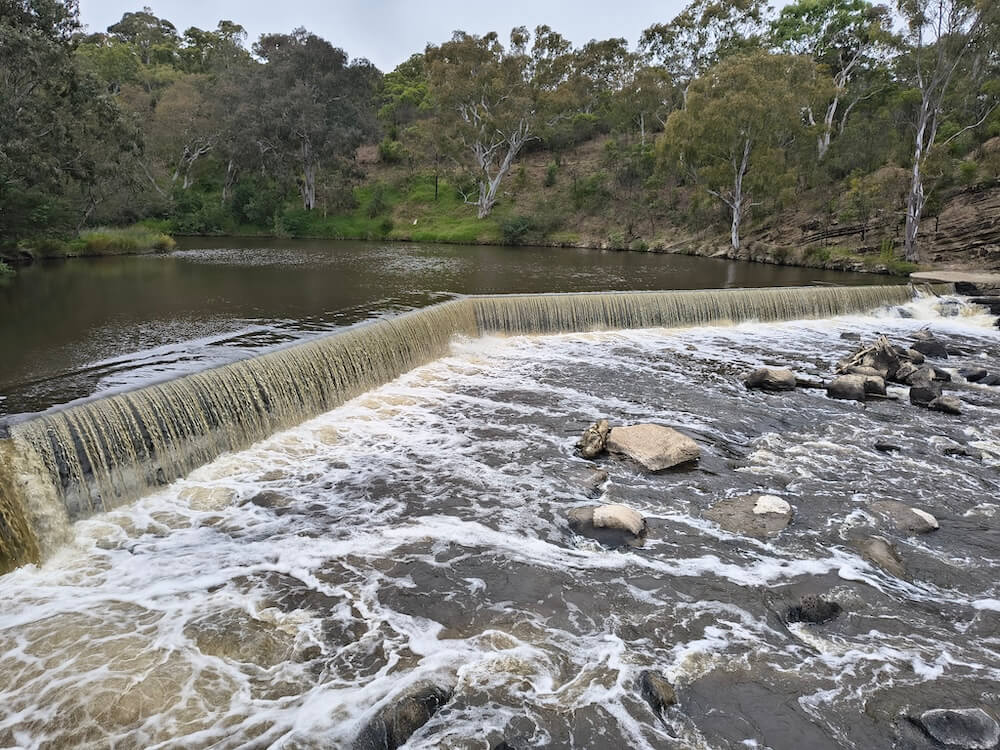 Water flowing over the broad artificial weir at Dights Falls on the Yarra River