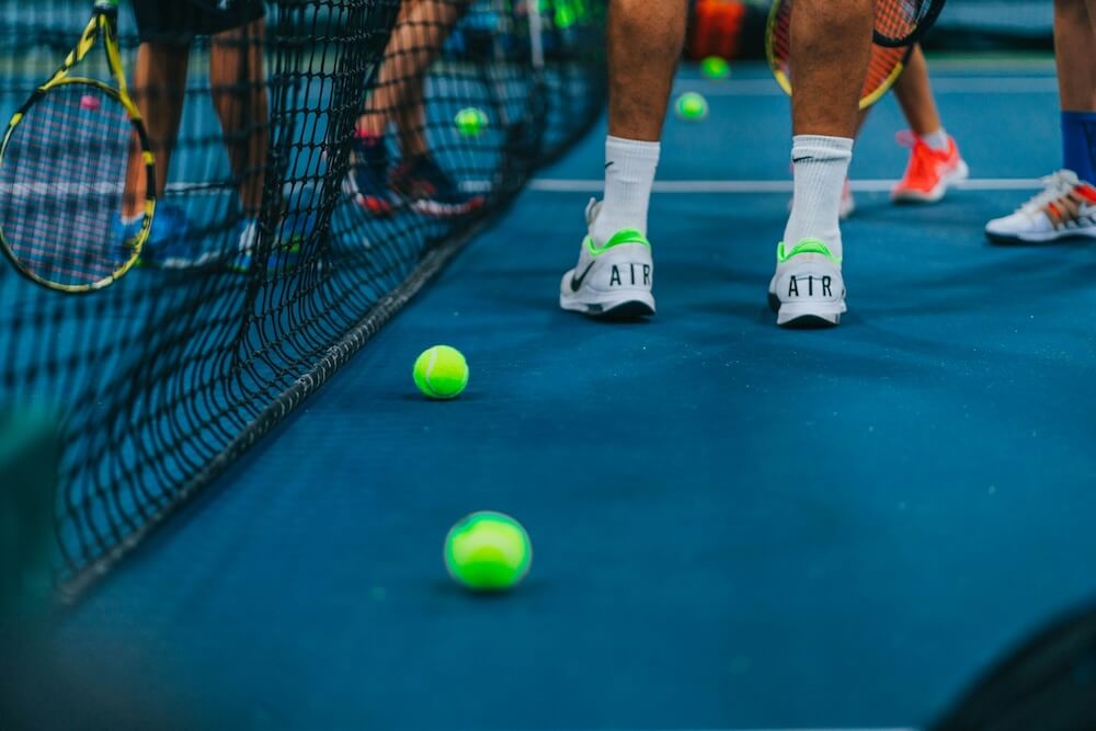 Tennis coach teaching a player on a tennis court in Gold Coast
