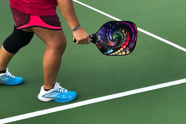 Person on a court with a pickleball racquet