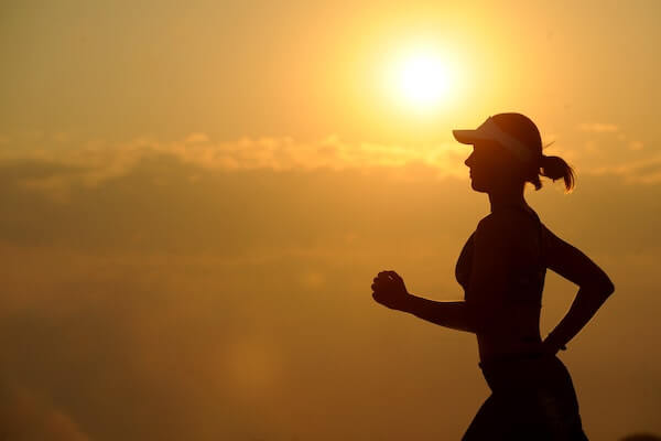 A lady running with sunrise in the background