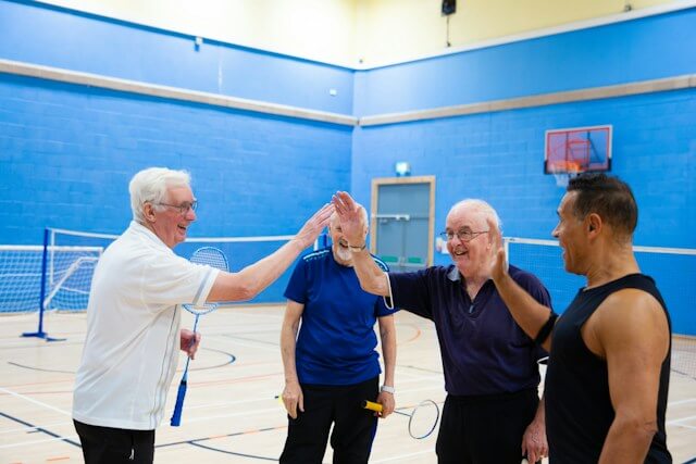 Older adults playing badminton together indoors