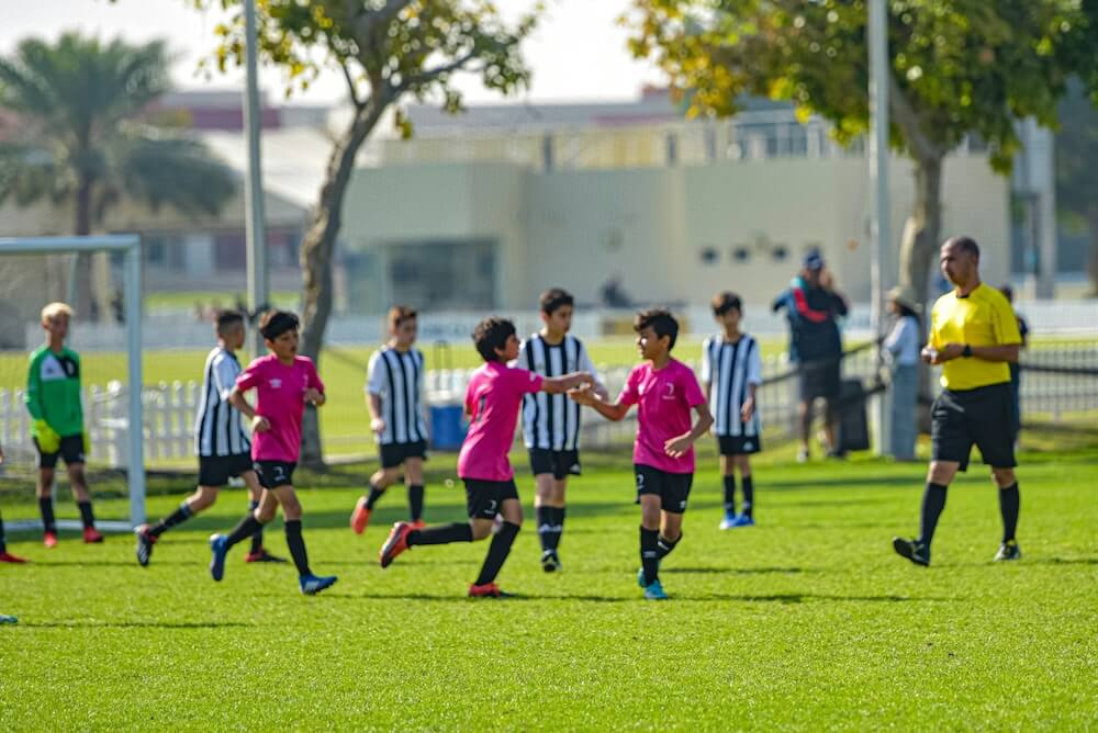 Junior soccer players in team uniforms during a community match