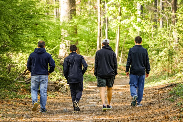 A group of men walking in a bush track